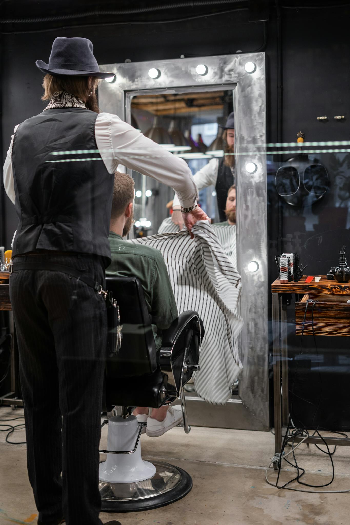 A barber skillfully styling a client's hair in a modern urban barbershop.