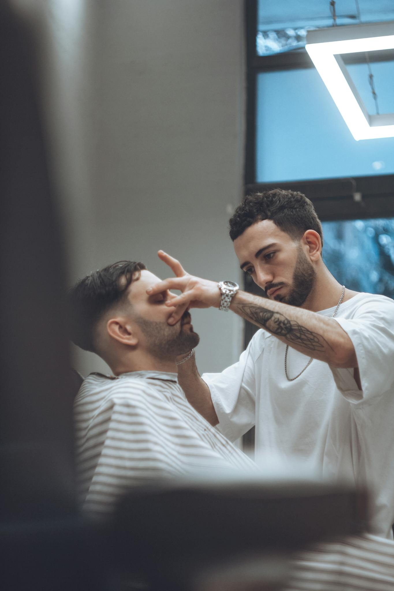 A professional barber skillfully giving a haircut in a modern salon in Tbilisi, Georgia.