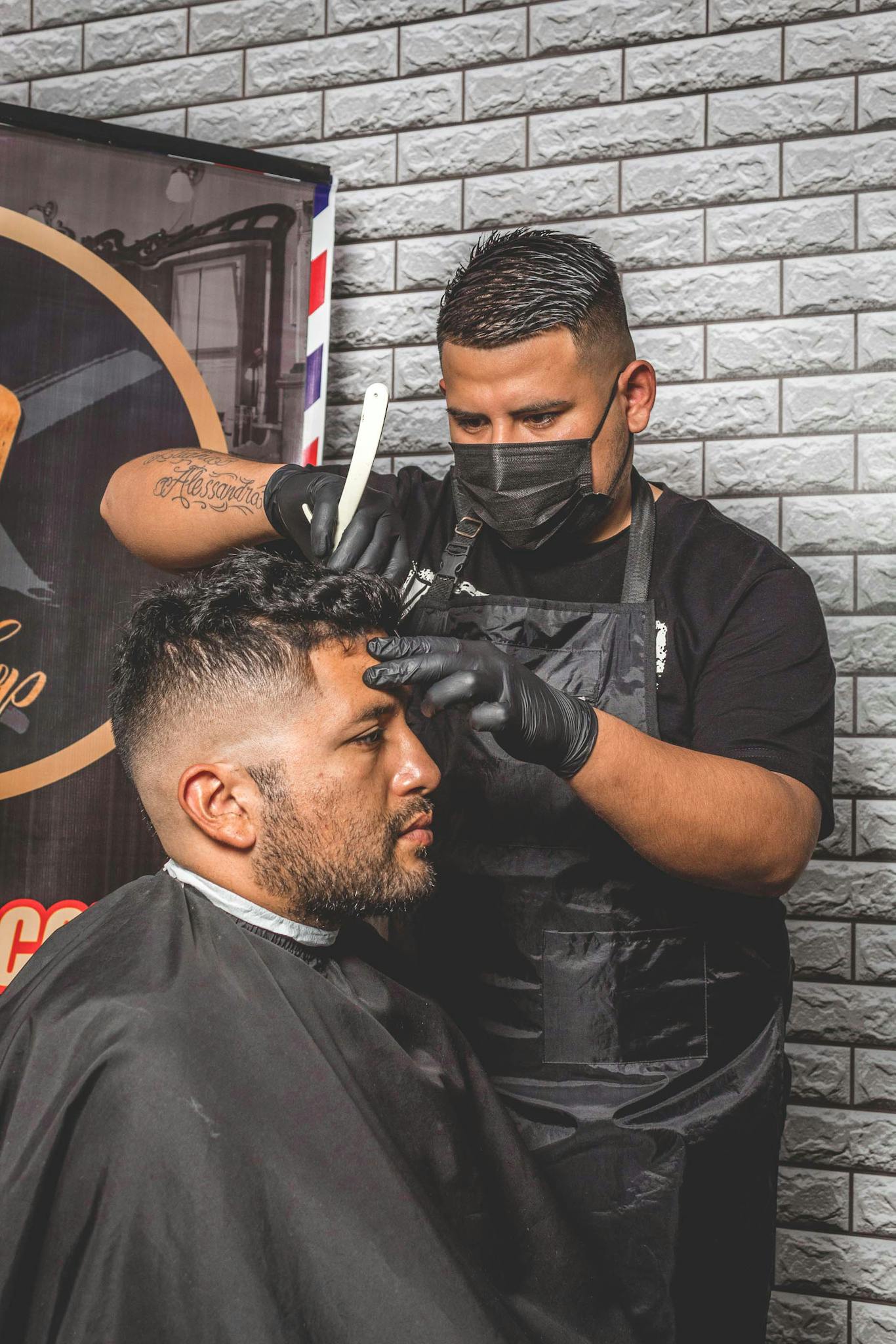Barber skillfully trims client's hair in a modern barbershop setting, showcasing barbering expertise.